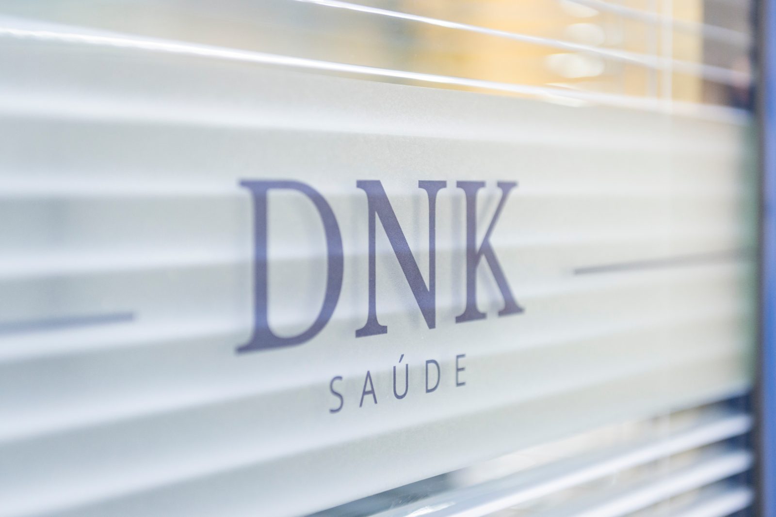 Divisória de vidro com o logo da DNK no escritório